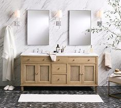 a bathroom with marble walls and two mirrors on the wall next to each other,