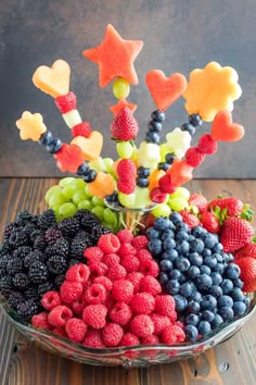 a glass bowl filled with fruit on top of a wooden table