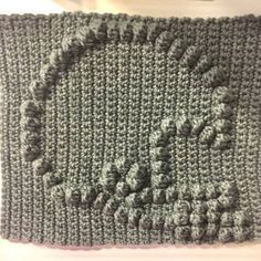 there is a crocheted square with the word love written on it in black and white