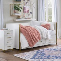 a bedroom with white furniture and pink accents