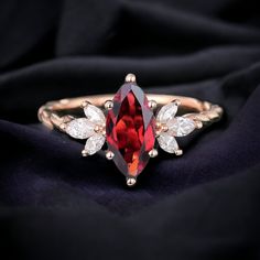 a close up of a ring with a red stone and white stones on it's side