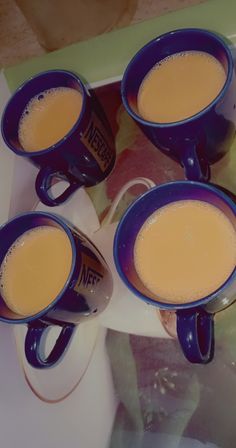 four cups of coffee sitting on top of a table