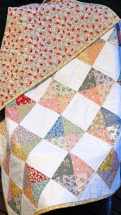 an old quilt sitting on top of a wooden bench