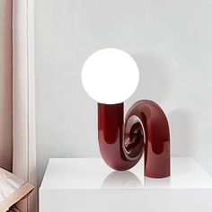 a red lamp sitting on top of a white table