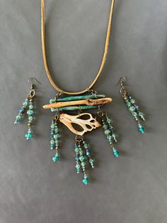 This pendant is made from a crosscut section of a shell, which hangs from painted wood and twig; blue-green beads shimmer and refract light with movements!  Such a fun piece to wear! The pendant measures are 5 inches long x 3.5 inches wide x 0.5 inches high.   The earrings measure 3.5 inches long from the top of the wire. My jewelry pieces are small works of art first; Then they are jewelry.  They are fragile due to the materials used.  Natural materials that make up the base of my pieces are usually either wood or shell, and both are organic and damaged by rough use.  The surfaces that have been painstakingly painted and adorned must be gently cared for.  Detergents, perfumes, hairsprays, etc... can easily damage the surfaces.  To clean, simply wipe gently with a soft cloth that is dry or Pendant With Beads, Abalone Necklace, Earthy Jewelry, Blues And Greens, Green Beads, Shell Pendant, Green Bead, Painted Wood, Bead Designs