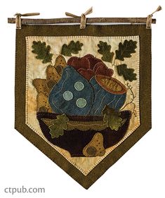 an embroidered banner with leaves and mushrooms on it