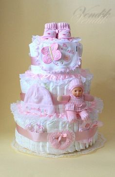 a pink and white baby shower cake on a table