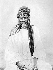 an old black and white photo of a man with a beard wearing a turban