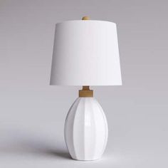 a white lamp with a wooden base and a white shade on the top, sitting in front of a gray background