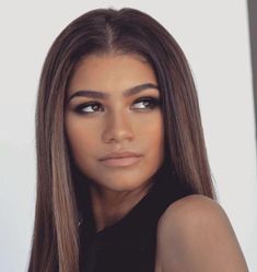 a beautiful young woman with long hair and blue eyeshadow posing for the camera