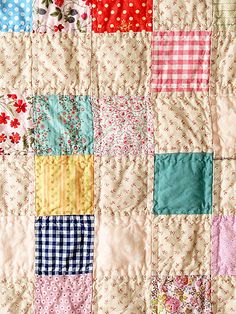 an old quilt with many different colored squares on it