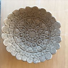 an intricately designed ceramic dish on a wooden surface