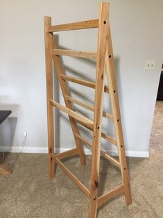 a wooden ladder leaning against a wall in a room with carpeted floor and white walls