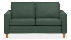 a green couch sitting on top of a white floor next to a wooden leg chair