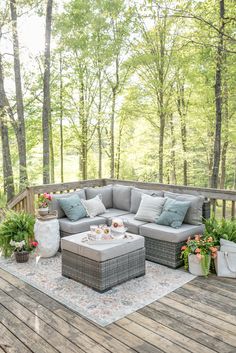 a couch and table on a deck in the woods