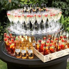 there are many glasses and bottles on the table with drinks in them, including apple cider