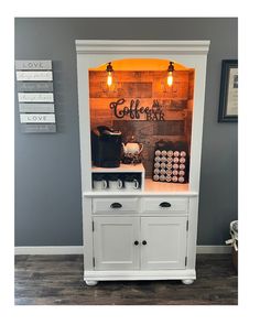 an old fashioned coffee shop display cabinet with lights on it's doors and drawers