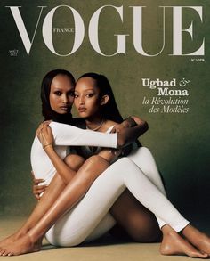 two women sitting on the cover of a magazine, one with her arms around the other