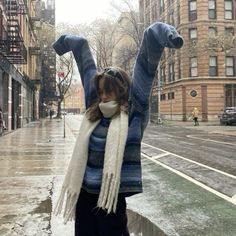 a woman standing in the rain with her arms up