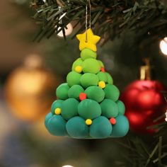 a christmas tree ornament hanging from a christmas tree with baubles on it