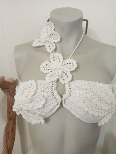 a mannequin wearing a white crochet bralet with flowers on it