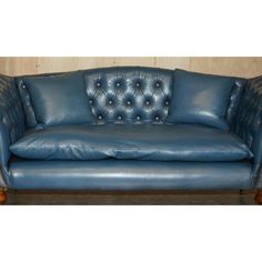 a blue leather couch sitting on top of a wooden floor