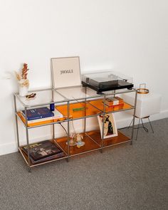 a glass table with books on it and a record player sitting on top of it