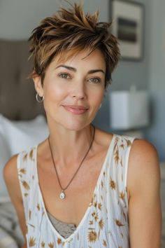 Person smiling with short, spiky hair, wearing a sleeveless top with a floral pattern and a necklace. Dimensional Highlights, Platinum Pixie, Edgy Pixie, Modern Punk, Spiky Hair, Subtle Highlights, Modern Vibe