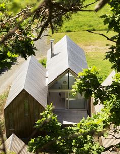 an aerial view of a small house in the woods with its roof made out of wood