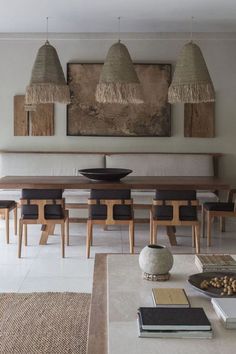 a dining room table with chairs and an art work on the wall