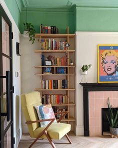 a living room filled with furniture and a fire place next to a book shelf covered in books