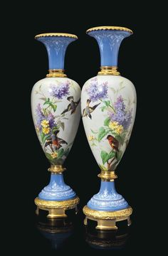 two blue and white vases sitting on top of each other with flowers painted on them