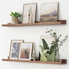 two wooden shelves with pictures and plants on them