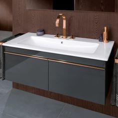 a bathroom sink sitting under a mirror next to a towel rack