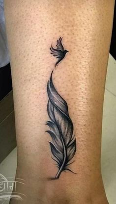 a black and white feather tattoo on the leg