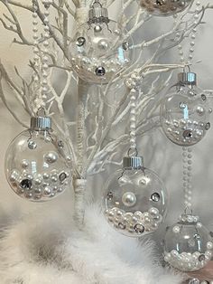 a white christmas tree with ornaments hanging from it's branches