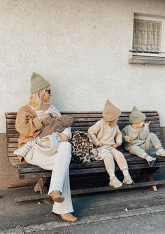 two women sitting on a wooden bench next to a child