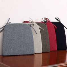 four different colored bags sitting on top of a wooden table