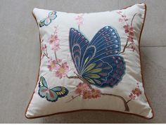 a blue butterfly on a white pillow with pink flowers