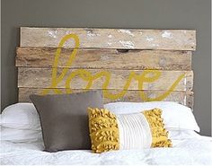 a bed with two pillows on it and a wooden sign above the headboard that says woop