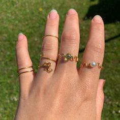 a woman's hand with three rings on it and the word love written in cursive writing