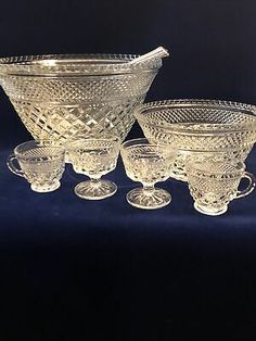 four glass bowls and two cups on a blue background