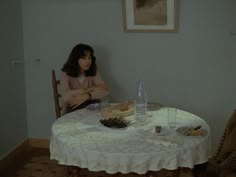 a woman sitting at a table with food on it