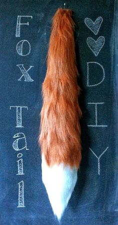 an orange and white cat tail laying on top of a chalkboard