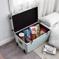 an open suitcase sitting on the floor with snacks in it