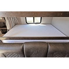 the inside of a camper with mattresses and ladders