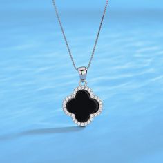 This exquisite necklace captures the essence of timeless charm, showcasing a black clover pendant adorned with meticulously placed cubic zirconia stones that add a touch of sparkle and elegance. Crafted with meticulous attention, it promises enduring brilliance and quality. The black clover motif, symbolizing fortune, combined with the shimmering pave contour, creates a versatile accessory that effortlessly enhances any look. Necklace length: 40+3cm;Pendant size 16*16mm;925 Sterling Silver;White Silver And Black Jewlery Necklaces, Cheap Symbolic Black Necklace, Affordable Classic Black Jewelry, Black Jewelry Necklace Silver, Cheap Black Necklaces For Gifts, Cheap White Symbolic Necklaces, Cheap Black Necklace For Gift, Cheap Black Pendant Jewelry, Affordable Black Necklace For Birthday Gift