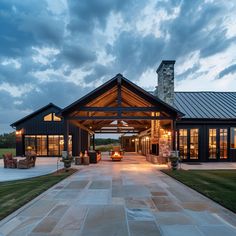 a large house with a covered walkway leading to the front door and patio area at dusk