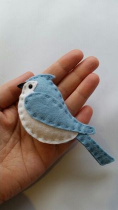 a hand holding a small blue bird on it's palm