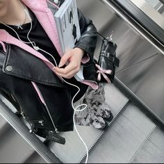 a woman sitting on an escalator with headphones and a laptop in her lap